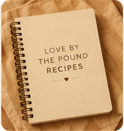 A spiral-bound Love by the Pound recipe journal on a linen cloth.